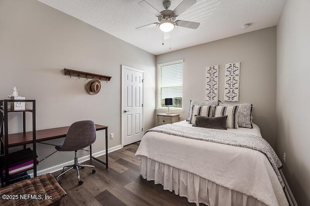 bedroom featuring dark wood-type flooring, ceiling fan, and a textured ceiling