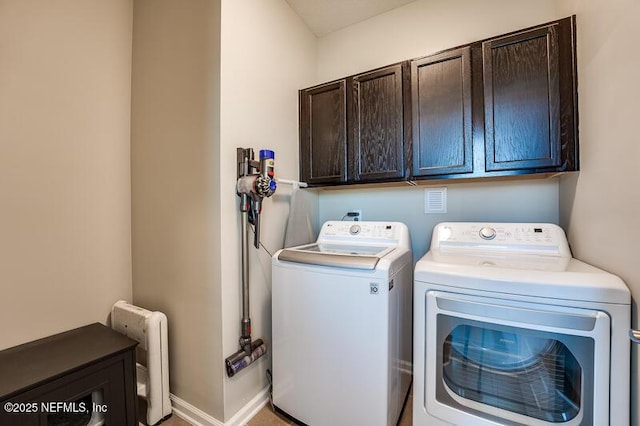 clothes washing area with cabinets, washing machine and clothes dryer, and radiator heating unit