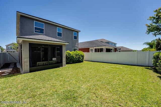 rear view of property with a lawn and a sunroom