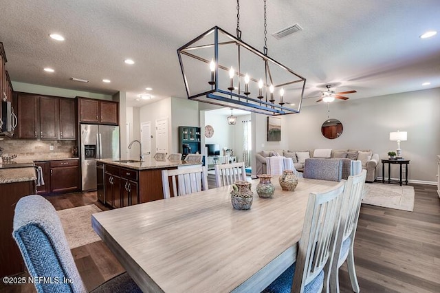 dining space featuring ceiling fan, dark hardwood / wood-style flooring, sink, and a textured ceiling