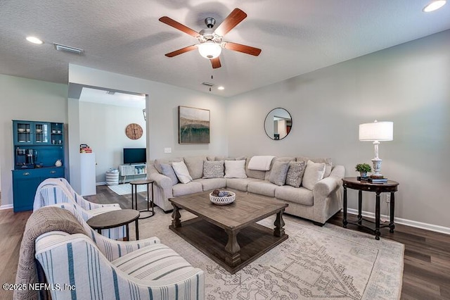 living room featuring ceiling fan, wood-type flooring, and a textured ceiling