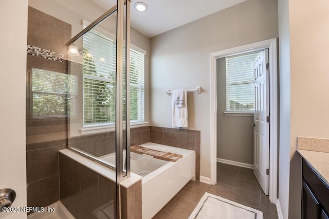 bathroom with tile patterned flooring, plus walk in shower, and a healthy amount of sunlight