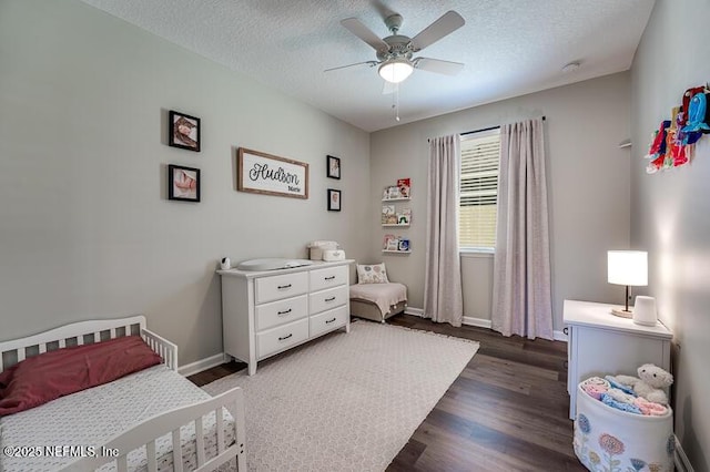 bedroom with ceiling fan, dark wood-type flooring, and a textured ceiling