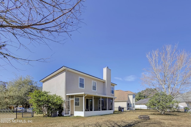 back of house with a sunroom and a fire pit