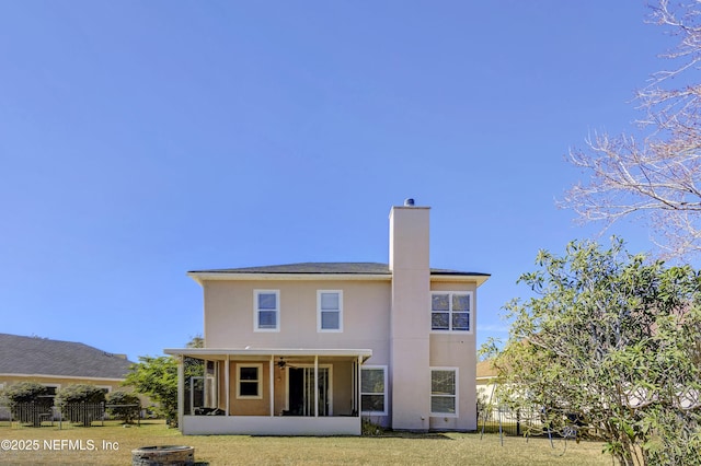 rear view of house with a sunroom and a lawn