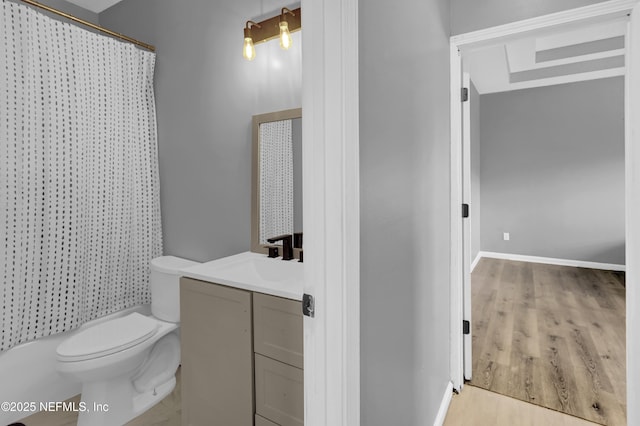 bathroom featuring hardwood / wood-style floors, vanity, curtained shower, and toilet