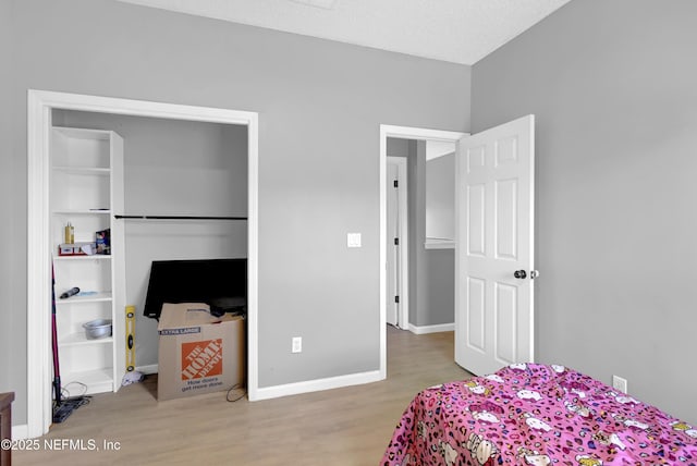 bedroom featuring a closet, light hardwood / wood-style floors, and a textured ceiling