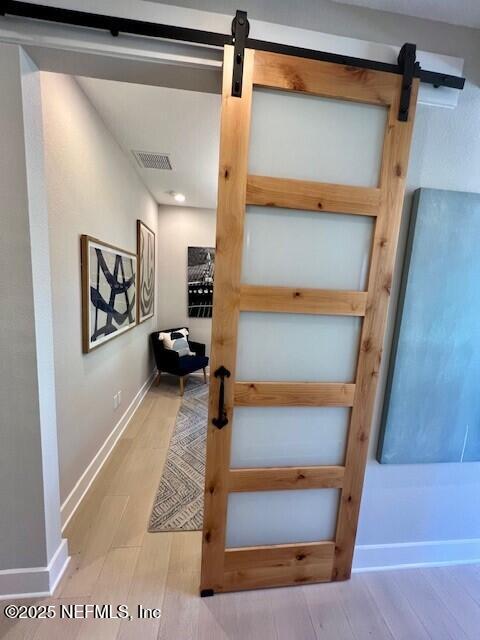 staircase featuring wood-type flooring and a barn door