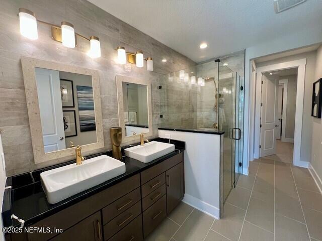 bathroom with tile patterned floors, an enclosed shower, and vanity