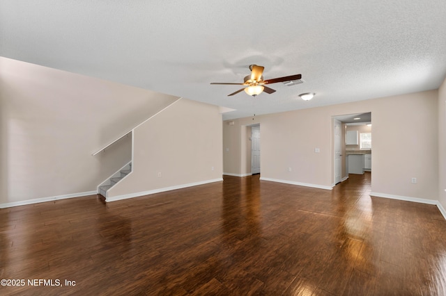 unfurnished living room with dark hardwood / wood-style flooring, a textured ceiling, and ceiling fan