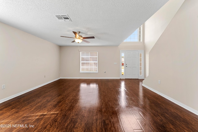 unfurnished living room with ceiling fan, dark hardwood / wood-style flooring, and a textured ceiling