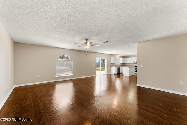 unfurnished living room with ceiling fan, dark hardwood / wood-style flooring, and a textured ceiling