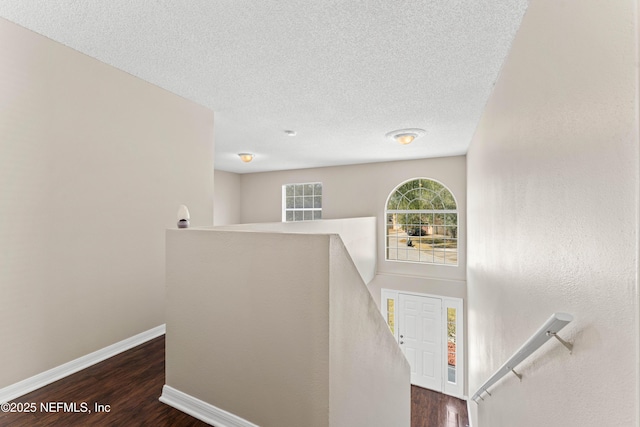 staircase featuring hardwood / wood-style floors and a textured ceiling