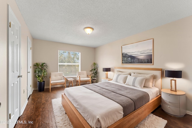 bedroom featuring dark hardwood / wood-style floors and a textured ceiling