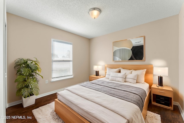 bedroom with dark wood-type flooring and a textured ceiling