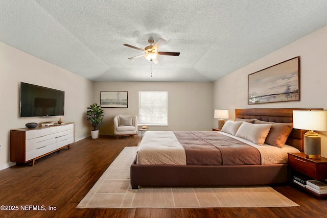 bedroom with dark hardwood / wood-style flooring, a textured ceiling, and ceiling fan