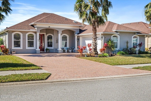 mediterranean / spanish-style home featuring a garage and a front yard