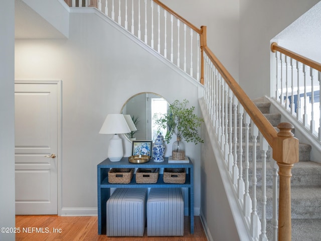 stairs with a towering ceiling and hardwood / wood-style floors