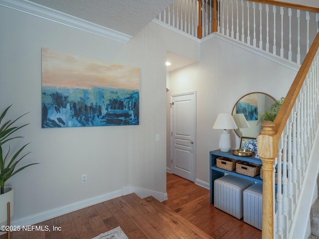 interior space with ornamental molding, hardwood / wood-style floors, and a textured ceiling