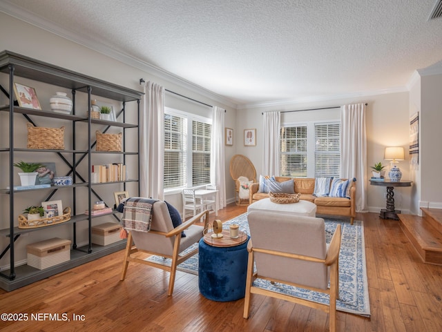 living room featuring ornamental molding, hardwood / wood-style floors, and a textured ceiling