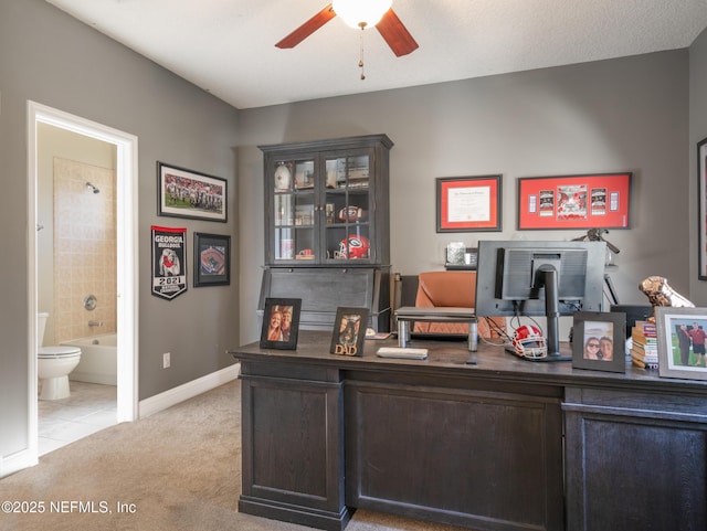 home office featuring light carpet and ceiling fan