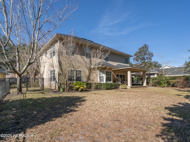 back of house with a lawn