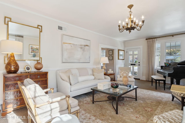 carpeted living room featuring crown molding and a chandelier