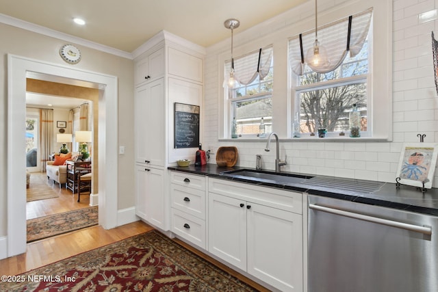 kitchen with sink, dishwasher, hanging light fixtures, hardwood / wood-style floors, and white cabinets