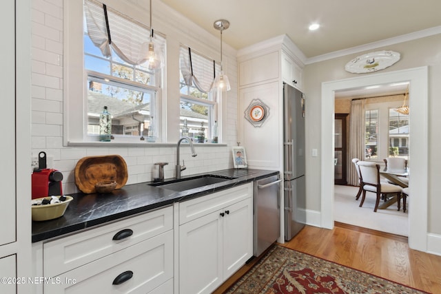 kitchen featuring sink, dark wood-type flooring, white cabinetry, backsplash, and stainless steel appliances