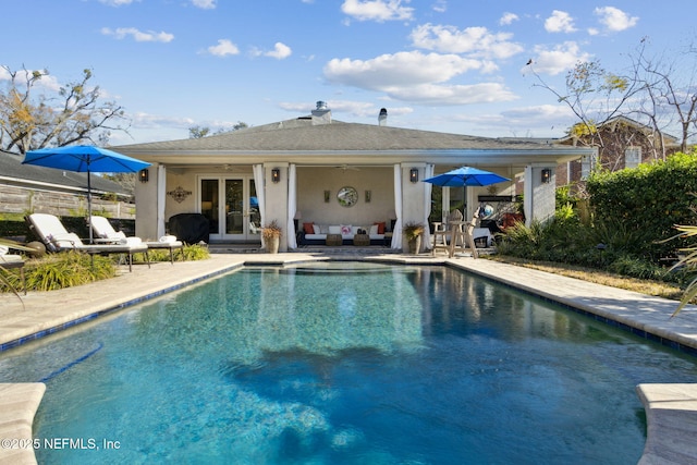 view of pool with french doors and a patio area