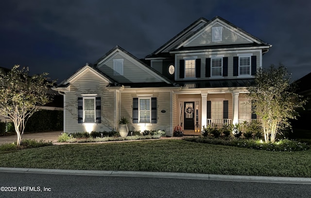 view of front of home with a porch and a lawn