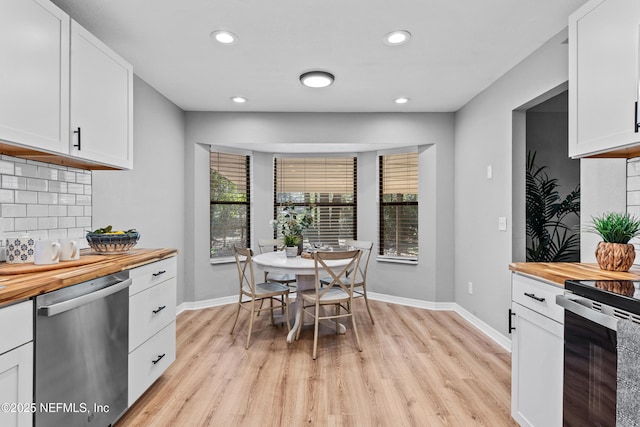 kitchen with wooden counters, a wealth of natural light, dishwasher, and white cabinets