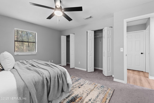 bedroom featuring ceiling fan, carpet, and two closets