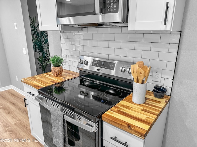 kitchen featuring stainless steel appliances, light hardwood / wood-style floors, decorative backsplash, and white cabinets