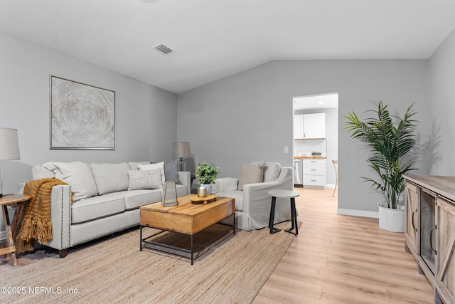 living room featuring vaulted ceiling and light wood-type flooring