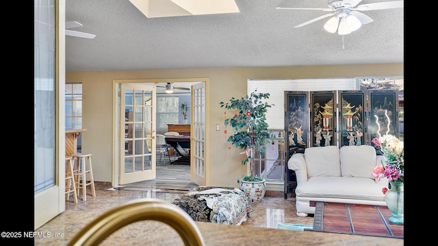 living room with a textured ceiling and ceiling fan