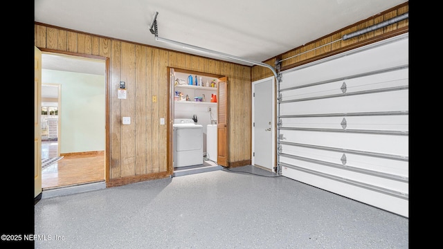 garage with separate washer and dryer and wooden walls