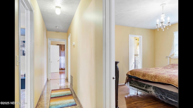 hallway with light hardwood / wood-style floors and a textured ceiling