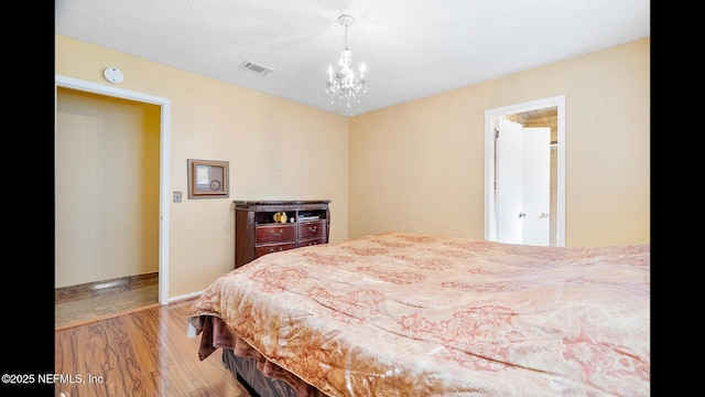 bedroom with a notable chandelier and light hardwood / wood-style flooring