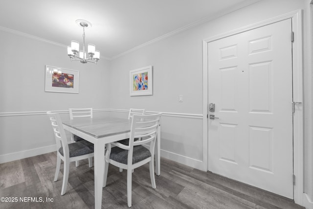 dining room featuring dark hardwood / wood-style flooring, ornamental molding, and an inviting chandelier