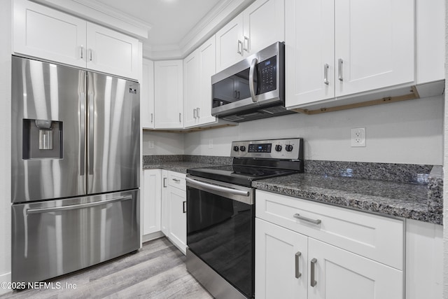 kitchen featuring white cabinetry, stainless steel appliances, light hardwood / wood-style floors, and dark stone counters