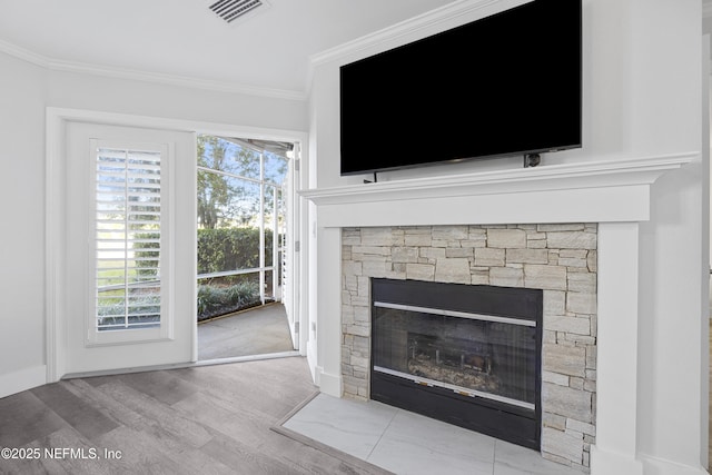 room details with hardwood / wood-style flooring, ornamental molding, and a stone fireplace