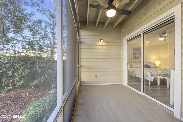 unfurnished sunroom with ceiling fan