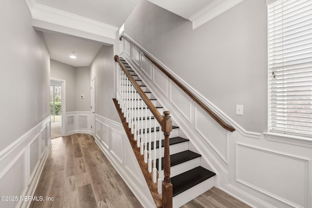 stairway featuring wood-type flooring and crown molding