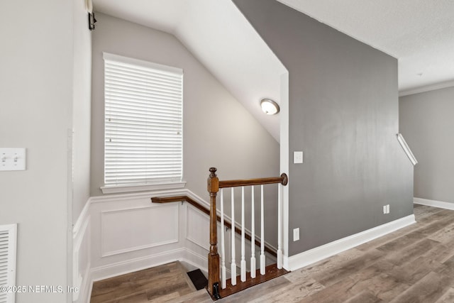 stairway featuring lofted ceiling and hardwood / wood-style floors