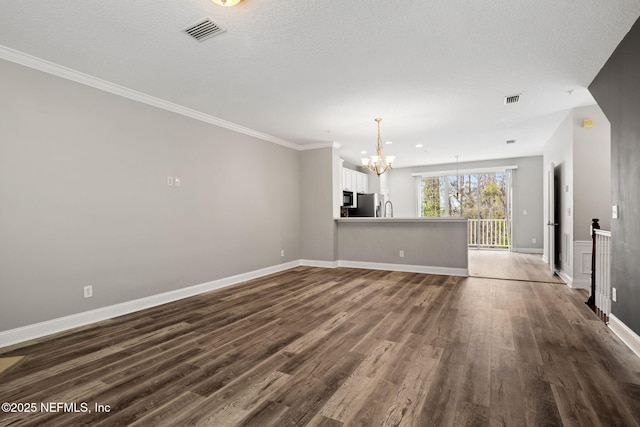 unfurnished room featuring dark hardwood / wood-style flooring, a notable chandelier, ornamental molding, and a textured ceiling