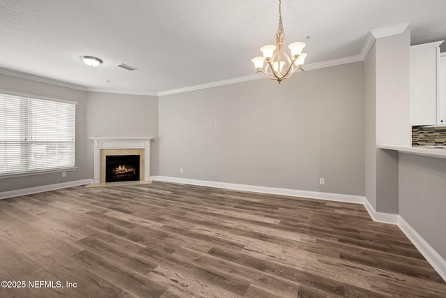 unfurnished living room with dark wood-type flooring, ornamental molding, a textured ceiling, and a notable chandelier