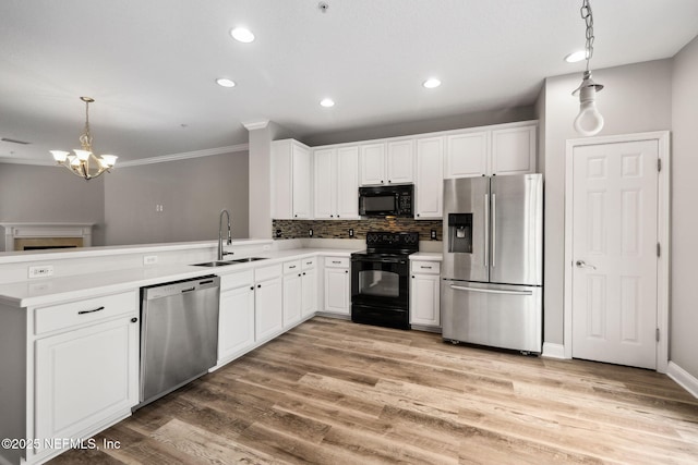 kitchen featuring sink, white cabinetry, pendant lighting, light hardwood / wood-style floors, and black appliances