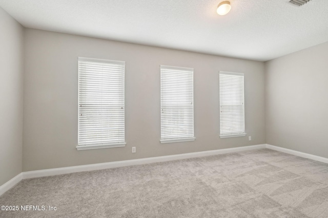 carpeted empty room with a textured ceiling