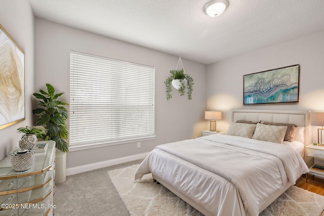 bedroom featuring light carpet and a textured ceiling